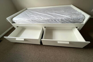 Close up of twin bed with drawers