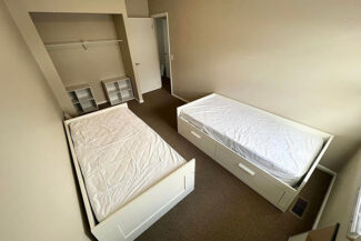 Bedroom with 2 beds and closet